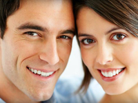 Close-up portrait of a young man and woman leaning together with bright smiles