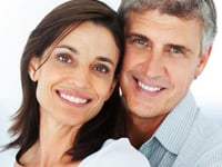 Portrait of a smiling middle-aged couple posing close together against a white background